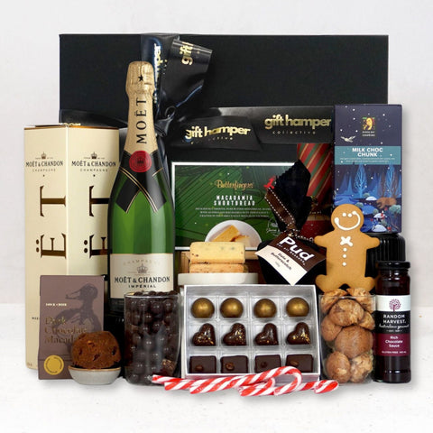 Gift hamper with Moêt champagne, chocolates, and other treats on a white background